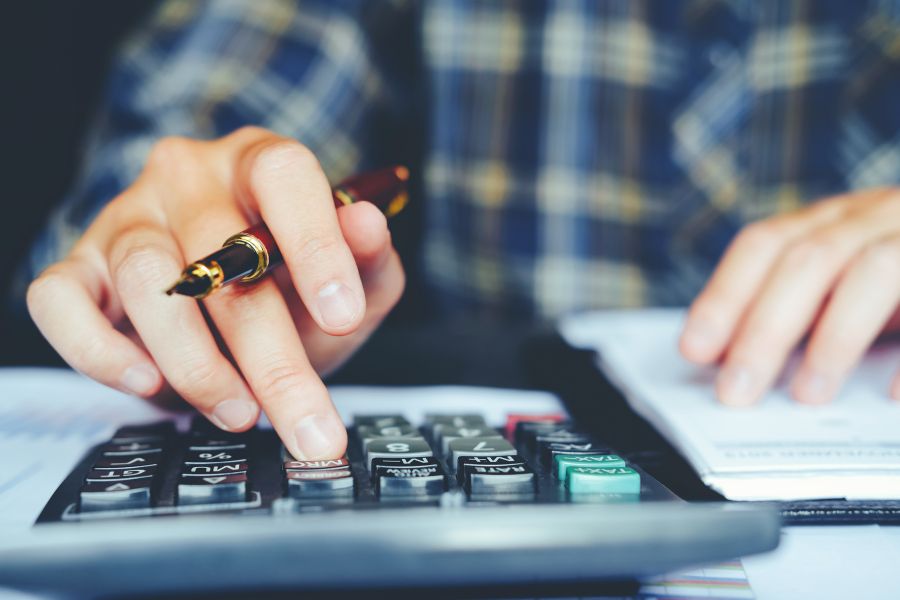 Businessman calculating the cost with calculator