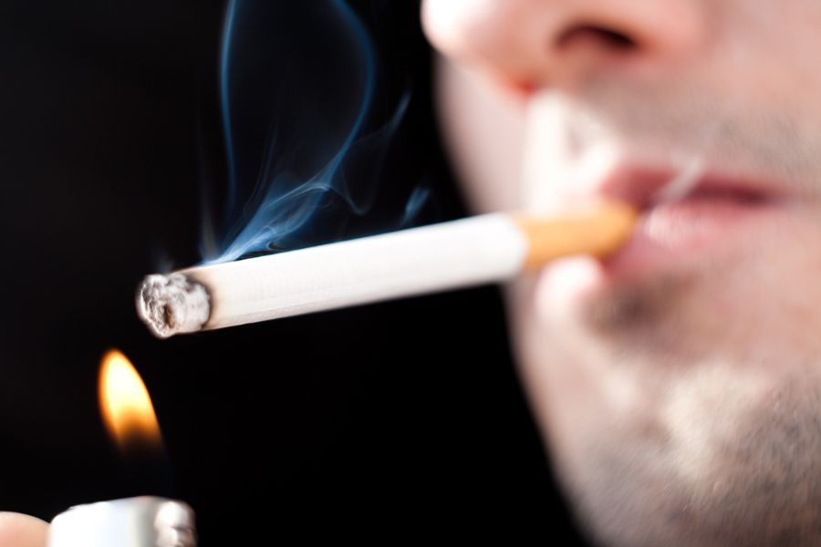 Man lighting up cigarette to smoke