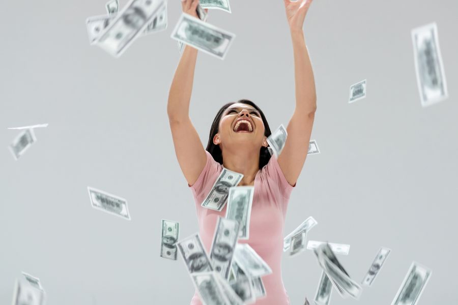 Happy woman grabbing dollars in the air 